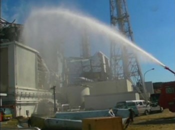 Um camião-cisterna lança água para o edifício do reactor 3