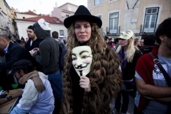 No dia da greve geral, manifestantes em frente ao Parlamento usam uma máscara associada ao grupo de hackers Anonymous