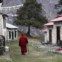 Um monge  caminha ao longo dos dormitórios dos monges mais jovens na aldeia Tengboche nos Himalaias  (no leste do Nepal)