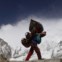 Um nepalês caminha com a sua carga vindo do acampamento de Evereste