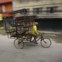 Homem transporta mercadorias na sua trishaw em Katmandu
