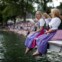 Algumas raparigas assistem ao desfile de barcos junto ao lago Grundlsee nos seus vestidos tradicionais Dirndl