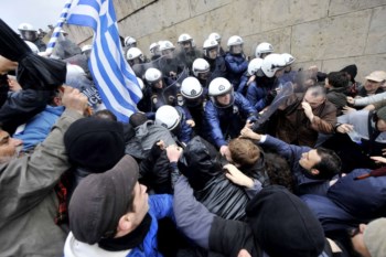 <p>Manifestantes tentam subir as escadas do edifício do Parlamento, em Atenas</p>