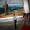 Coreia do Norte, 29.08.2011 | Um turista chinês posa para uma fotografia com um retrato do líder norte-coreano Kim Jong-il como cenário, num auditório da cidade de Rason, a nordeste de Pyongyang. 