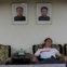 Um turista chinês dorme sob os retratos (omnipresentes na Coreia do Norte) do