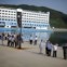 Representantes das autoridades norte-coreanas despedem-se dos turistas no porto de Kumgang. 