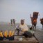 Paquistão, Carachi, 09.09.2011 | Junto à praia, Sughra vende milho assado enquanto os camelos, destinados a passeios, passam. 