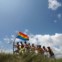 Sinais da abertura: um grupo de homens com a bandeira arco-íris da comunidade gay durante a abertura de um encontro de Verão numa praia perto de Havana 