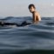 BRASIL, 05.07.2012. Um pinguim nada junto de um surfista na praia do Arpoador, Rio de Janeiro. 