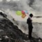 BANGLADESH, 19.01.2013. Um rapaz brinca com balões junto ao rio Buriganga (o fumo que se vê é de uma lixeira). Em Dhaka. 