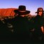 Um grupo de turistas observa o pôr-do-sol no Uluru
