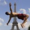 FRANÇA, 19.7.2013. Um rapaz salta numa fonte da praça Trocadero em frente da Torre Eiffel