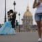 FRANÇA, 16.08.2013. Um casal na ponte Alexandre III com a Catedral de Saint Louis des Invalides no horizonte  