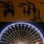 França, Marselha. Reflexos de visitantes em painéis espelhados desenhados por Norman Foster e um detalhe de uma roda gigante de feira de Natal
