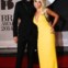 Rita Ora num vestido Prada com Calvin Harris num fato Emporio Armani