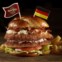 Alemanha, Colónia: Schnitzel Burger com lombo de porco ligeiramente panado coberto com bacon, alface, tomate, couve salteada e mostarda Dijon, servido num pão pretzel aquecido.