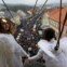Raparigas vestidas de anjo estão suspensas num cabo num mercado de Natal em Ustek, República Checa