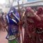 Mulheres indianas com varas de bambu nas celebrações do Festival das Cores