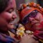 Mulheres seguram uma representação da deusa hindu Radha durante o Festival das Cores