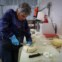 A voluntária Simonetta Lanzi corta queijo no Cáritas Emporium
