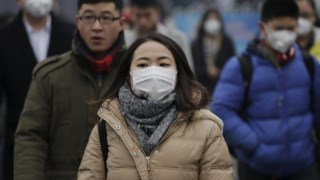 Pedestres usam máscaras de protecção durante "alerta vermelho" contra a poluição em 2015, em Pequim, China