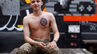 Cadete militar de 18 anos, Maksym, posa depois de ter feito a sua primeira tatuagem.