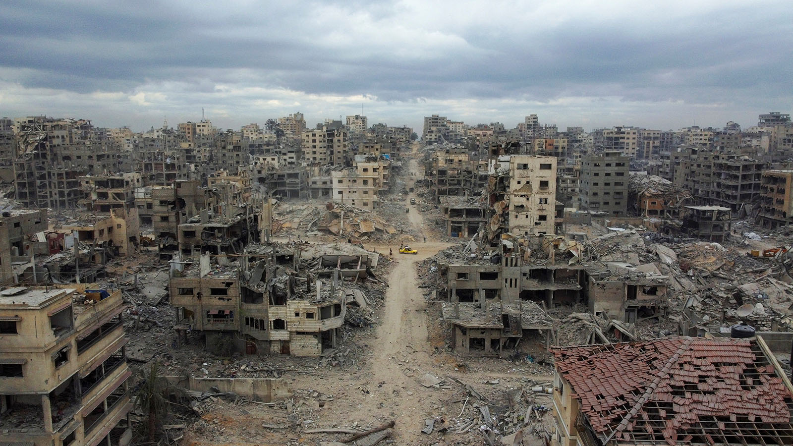 A drone view shows Palestinians walking past rubble following the withdrawal of the Israeli forces from the area, amid a ceasefire between Israel and Hamas in Gaza, in Gaza City, October 12, 2025. REUTERS/Stringer