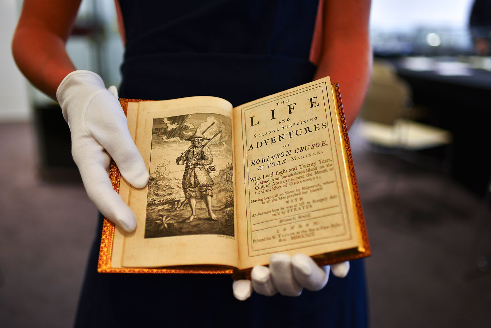 An original first edition of the book Robinson Crusoe by English author Daniel Defoe, which was first published in 1719 is held at a preview of the sale of English Literature, History Children's Books and Illustrations at Sotheby's auction house in London, on July 5, 2019. (Photo by Alberto Pezzali/NurPhoto via Getty Images)