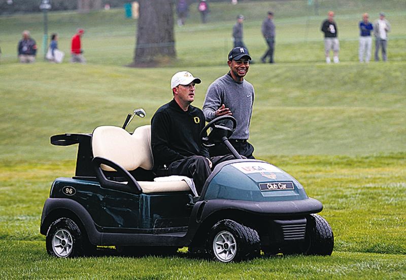 Casey Martin em um carrinho de golfe ao lado de Tiger Woods que seguia a pé