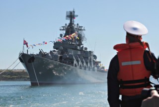 Marinheiro olha para o navio russo <i>Moskva</i>, no porto ucraniano de Sevastopol, na Crimeia, em 2013